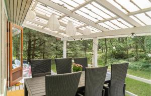 eine Terrasse mit Tisch und Stühlen unter einer Pergola in der Unterkunft 3 Bedroom Beautiful Home In Nexø in Neksø + 8 Fotos