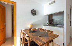 a kitchen with a wooden table and a clock on the wall at Pet Friendly Apartment In Torrevieja in Torrevieja