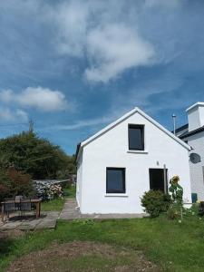 a white house with a bench in front of it at Glandore 2 bedroom house in Glandore