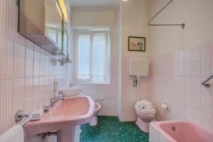 une salle de bains rose avec lavabo et toilettes. dans l'établissement Simply Romantic Sea View - Happy Rentals, à Alassio