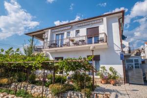 una casa blanca con balcones y plantas en Apartments and rooms Premium Relax, en Novi Vinodolski