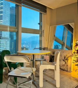 a table and chairs in a room with a large window at Reve House in Ansan