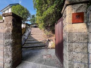 a set of stairs with a gate and a brick wall at KIYOMORI in Hatsukaichi