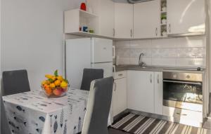 a kitchen with a table with a bowl of fruit on it at Awesome Apartment In Crikvenica in Crikvenica +14 photos