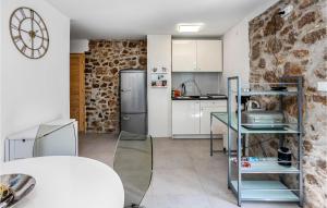 a kitchen with a table and a refrigerator at 3 Bedroom Nice Home In Karlobag in Karlobag