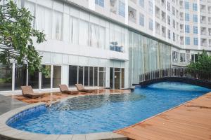 a swimming pool in front of a building at Lavish 2BR Apartment at Grand Sungkono Lagoon By Travelio in Surabaya