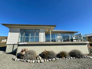 a house with a balcony and some bushes at Braeview in Lake Tekapo
