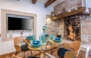 a dining room with a table and chairs and a fireplace at Beautiful Home In Krnica With Sauna in Krnica