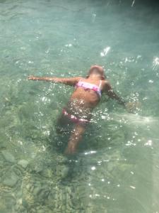 a woman in the water in the ocean at Apartments Villa Stella Maris in Rogoznica
