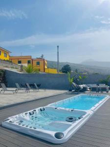 a swimming pool sitting on a deck with chairs at Villa SOHLARA in La Orotava
