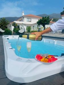 a person pouring wine into a table with a plate of food at Villa SOHLARA in La Orotava