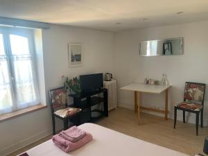 a room with a bed and two chairs and a table at Maison de centre-ville in Cognac +3 photos