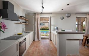 une cuisine avec des placards blancs et une grande fenêtre dans l'établissement Villa Megi, à Sveti Lovreč Pazenatički