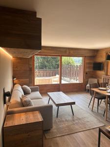 a living room with a couch and a table at Studio Cosy cœur de Megève Le Soleil Levant in Megève