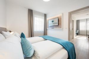 沃尔特湖畔韦尔登弗洛拉别墅酒店的卧室里有一张白色的大床，配有蓝色的枕头