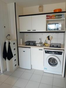 a kitchen with a washing machine and a microwave at Le Cœur des Océanes in Pornichet +17 photos