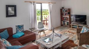 un soggiorno con un divano e un tavolo di Kingfisher Cottage a Kei Mouth