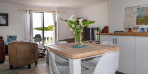 un tavolo da pranzo con un vaso di fiori sopra di Kingfisher Cottage a Kei Mouth