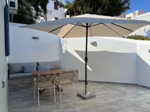 an umbrella on a patio with a table and chairs at Fedon in Halki
