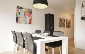a dining room with a white table and chairs at Holiday Home Havnevej Ulfborg Ix in Thorsminde