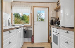 a kitchen with white cabinets and a white door at Nice Home In Bogø By With Wifi in Bogø By