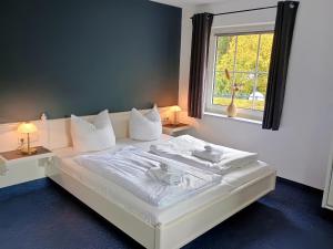 a white bed in a room with a window at Excellent Hotel Hamburg in Hamburg