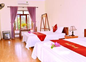 a hotel room with two beds and a tv at tam coc familyfriendly homestay in Vũ Lâm
