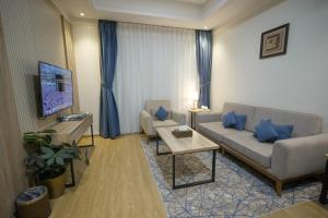 a living room with a couch and a table at عز الدولية للشقق المخدومه Ezz International for Serviced Apartments in Jeddah