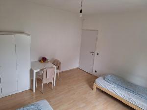 1 dormitorio con escritorio, 1 cama y 1 mesa en Malamin, en Heilbronn