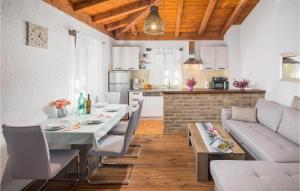 eine Küche und ein Wohnzimmer mit einem Tisch und einer Couch in der Unterkunft One-Bedroom Holiday Home In Svlovrec in Rajki