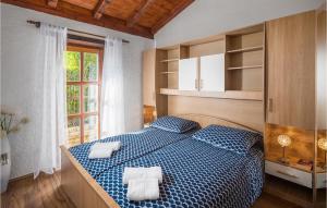 ein Schlafzimmer mit einem blauen Bett mit zwei Handtüchern darauf in der Unterkunft One-Bedroom Holiday Home In Svlovrec in Rajki