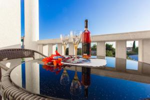 a table with two glasses and wine bottles on a balcony at Apartments Srdarev Pencov in Vodice