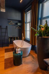 a large bathroom with a tub and a plant at Maison Brunon in Bruges