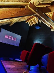 a room with a netflix sign and chairs in it at LE COCON l'unique expérience Cinéma room de la Grange Savoyarde 1km du Lac d'Annecy in Lathuile