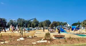 a group of people at a park with a playground at Brand New House in Lakes Entrance in Lakes Entrance