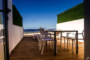 a table and chairs on a balcony with the beach at Apartamentos Tocororo in El Cotillo