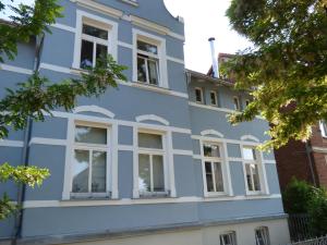ein blaues Gebäude mit weißen Fenstern in der Unterkunft Morizan in Röbel