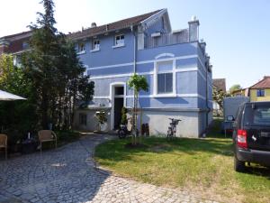 ein blaues Haus mit einem davor geparkten Auto in der Unterkunft Morizan in Röbel