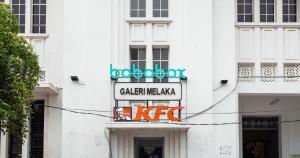 a sign on the side of a white building at Bobopod Kota Tua, Jakarta in Jakarta