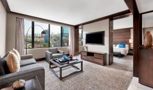 a living room with a couch and a tv at Mandarin Oriental, Jakarta in Jakarta