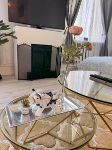 a glass table with a vase and a teddy bear on top of it at Cozy apartment in Rīga