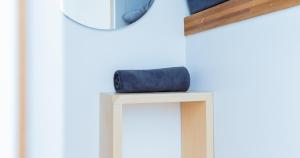 a blue wallet sitting on a stool in front of a mirror at Bobopod Kota Tua, Jakarta in Jakarta