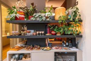 a shelf with plates of food and plants on it at Maison Brunon in Bruges