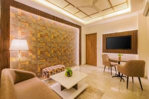 a living room with a couch and a table at Kyomi Service Apartments in Gurgaon