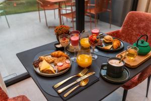 a table topped with plates of food and glasses of orange juice at Maison Brunon in Bruges +41 photos