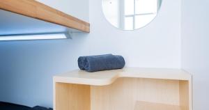 a blue towel sitting on a table next to a mirror at Bobopod Kota Tua, Jakarta in Jakarta
