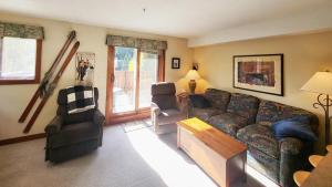 a living room with a couch and two chairs at Timberline Village #46 home in Sun Peaks
