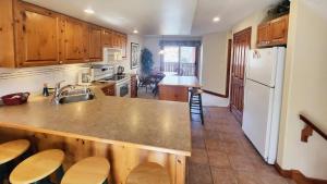 a kitchen with a sink and a refrigerator at Timberline Village #46 home in Sun Peaks
