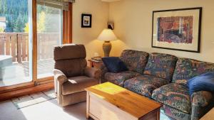 a living room with a couch and a chair at Timberline Village #46 home in Sun Peaks