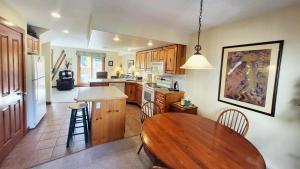 a kitchen with a wooden table and a dining room at Timberline Village #46 home in Sun Peaks